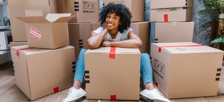 Woman sitting in front of boxes and smiling