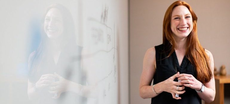 A woman in front of a whiteboard. 