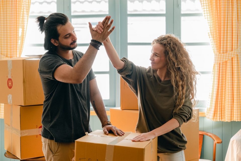 woman high-fiving a man after managing to move into an apartment in a day