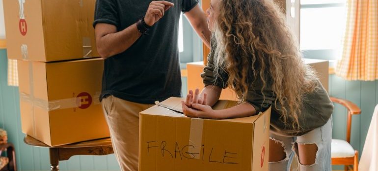 Person leaning on a box that is labeled as fragile.
