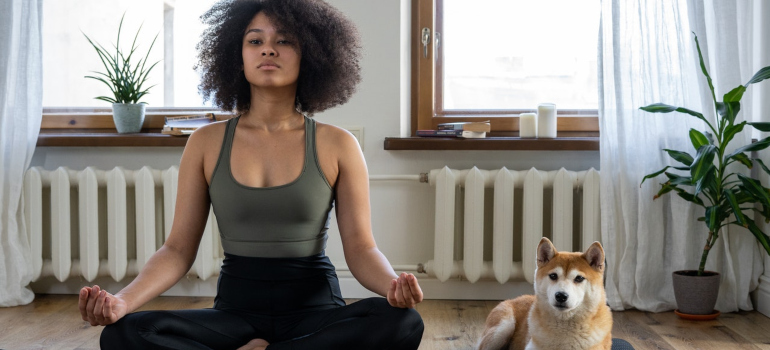 a girl meditating next to her dog