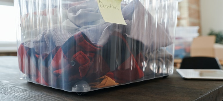 Clothes in a plastic box labeled Donation