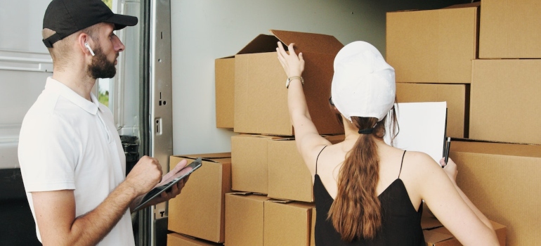Professional movers loading moving truck with office equipment