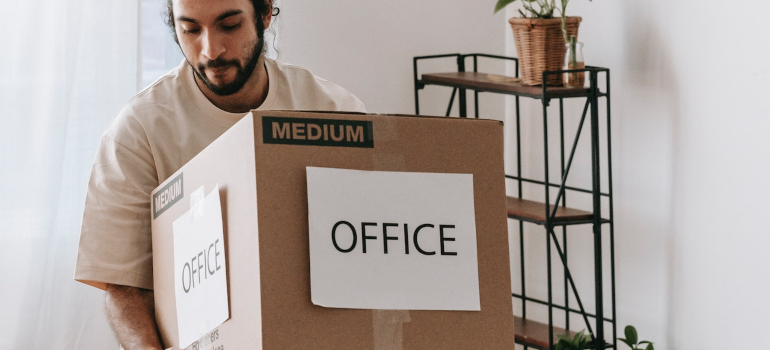 a person holding a box with sign office on it