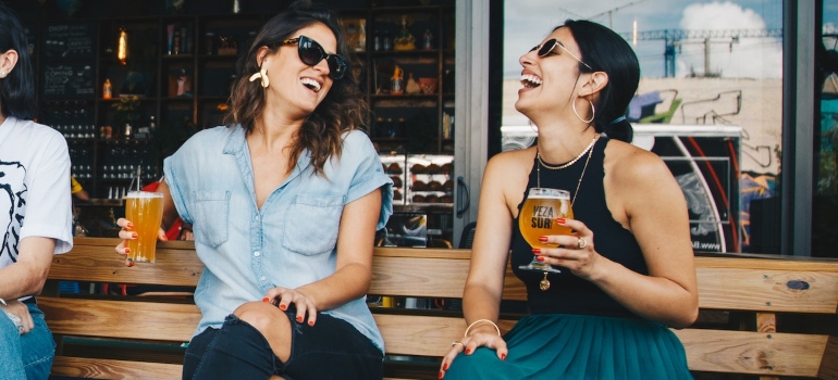 two girls in a bar talking and smiling 