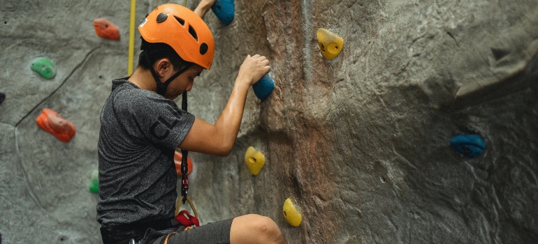 A boy climbing with gear