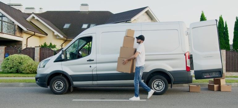 mover carrying boxes next to a van